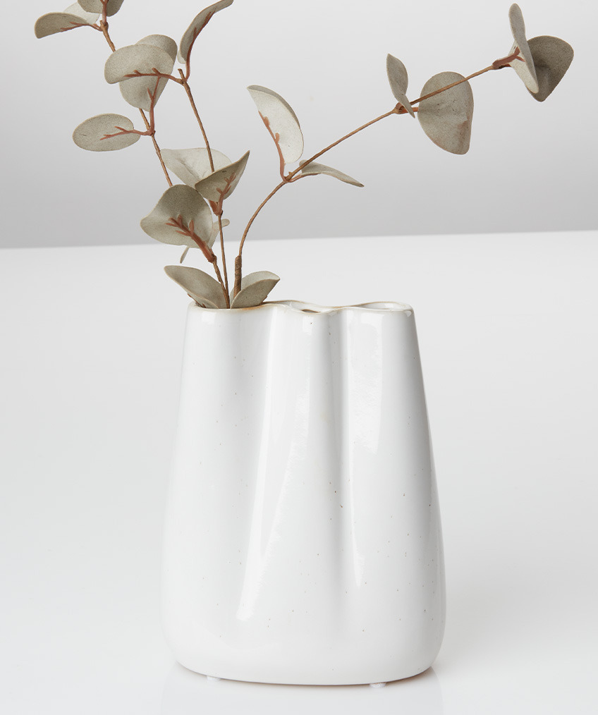 Bela vaza na mizi z umetnim cvetjem