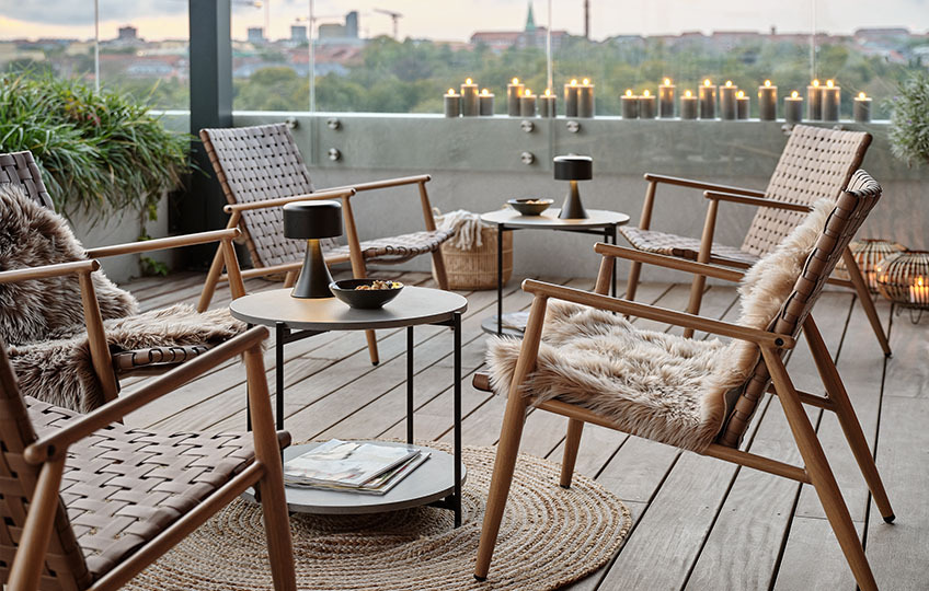 Manjša vrtna mizica z mizno ploščo iz vlaknastega cementa in lounge stola na terasi