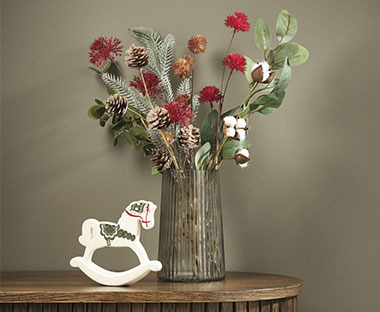 Lesen konjiček kot božična dekoracija ob vazi z umetnim cvetjem