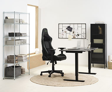 Računalniški stol z dvižno mizo in vitrina v domači pisarni