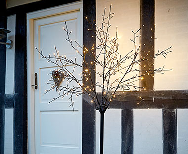 Božično drevo z lučkami pred hišo