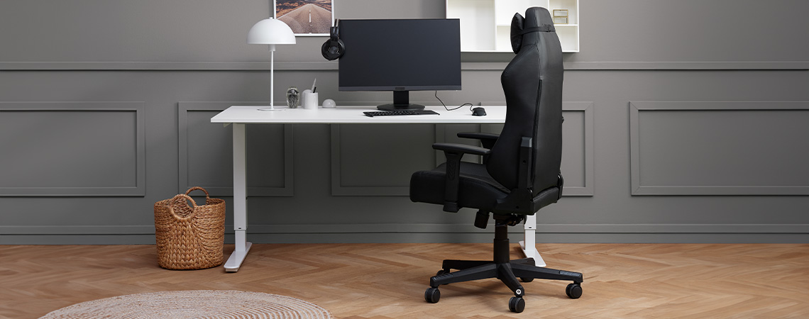 Eleganten, eleganten in ergonomski gaming stol ob dvižni mizi z monitorjem in slušalkami