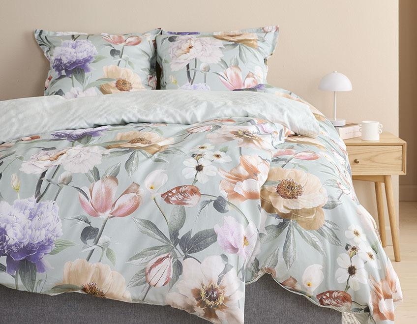 Postelja prekrita s posteljnino z velikimi rožami