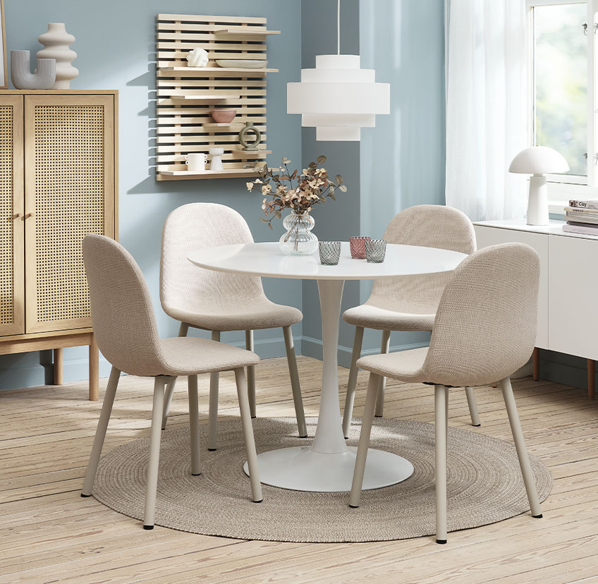 Jedilniški stoli v svetlo bež barvi ob beli okrogli jedilniški mizi