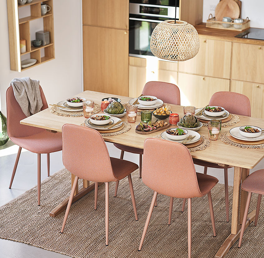 Čudoviti jedilniški stoli v nežni roza-breskev barvi ob veliki jedilni mizi