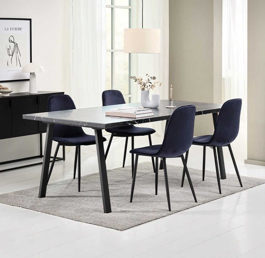 Jedilniški stol v temno modri barvi iz žameta ter jedilniška miza v barvi črnega marmorja