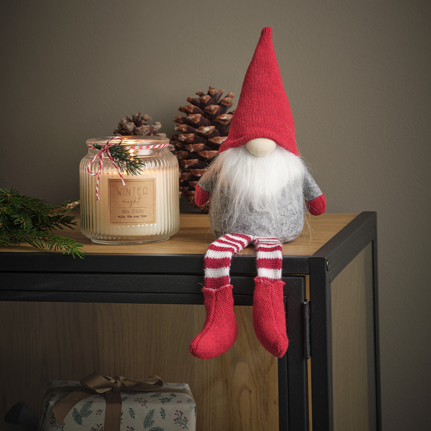 Božični škrat z belo brado, rdečo kapo in nogavicami