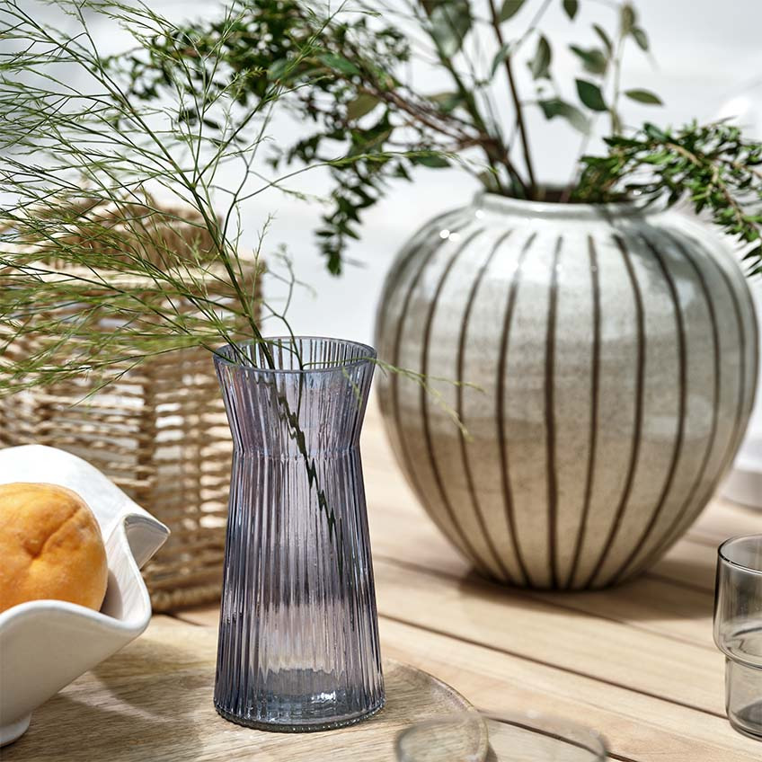 Vaze, lanterne in sklede na leseni vrtni mizi na terasi