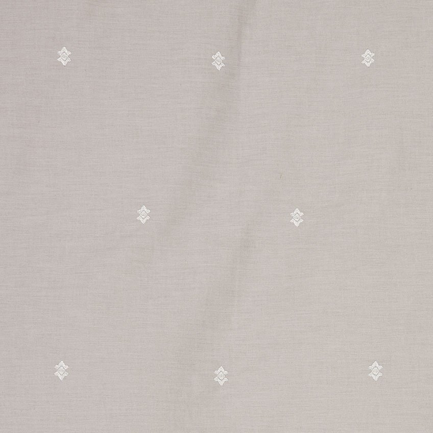 Izsek drobne vezenine v beli barvi na sivi posteljnini