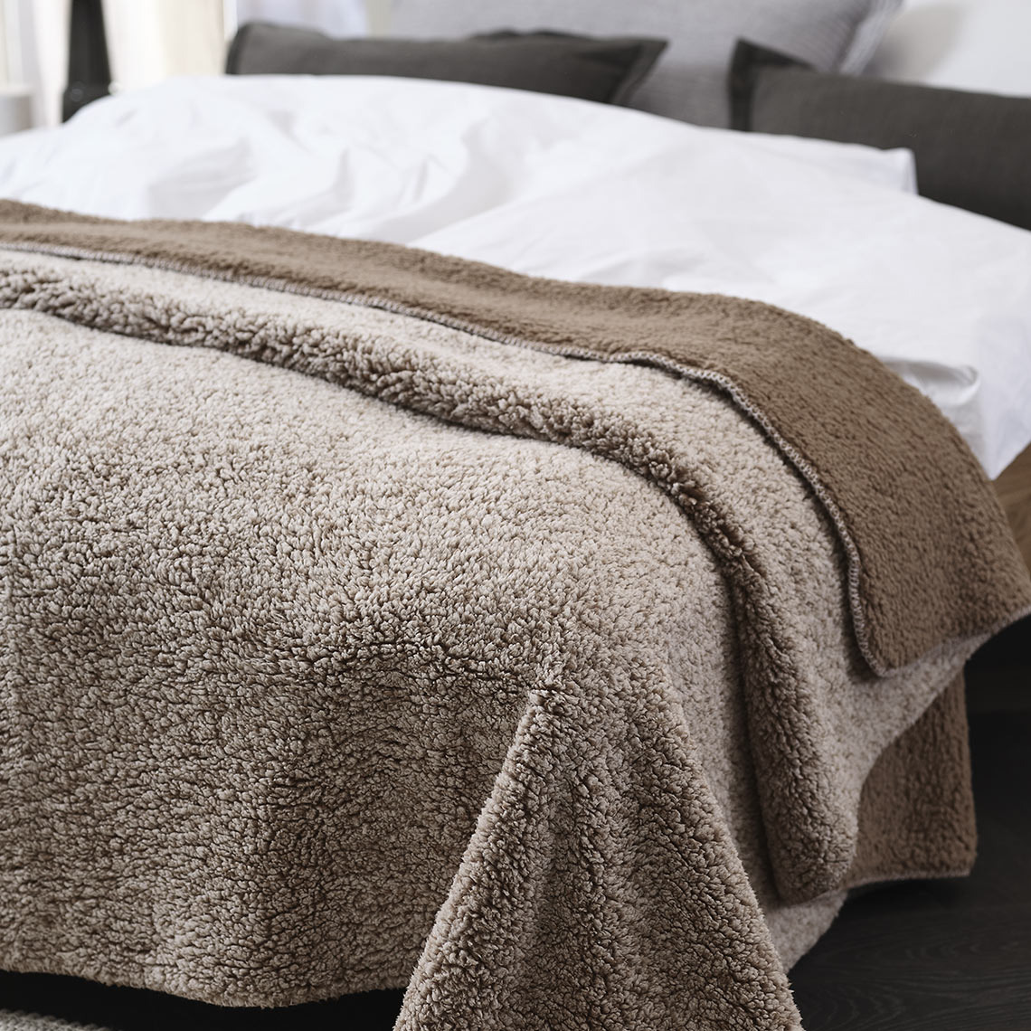 Rjava flis odeja na postelji v spalnici