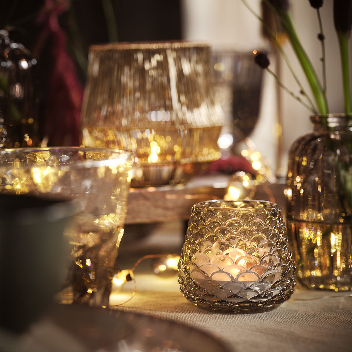 Svečnik BIFROST za čajne svečke Jedilna miza, ki je osvetljena s svečami in čajnimi svečkami v svečnikih za čajne svečke in verigami lučk