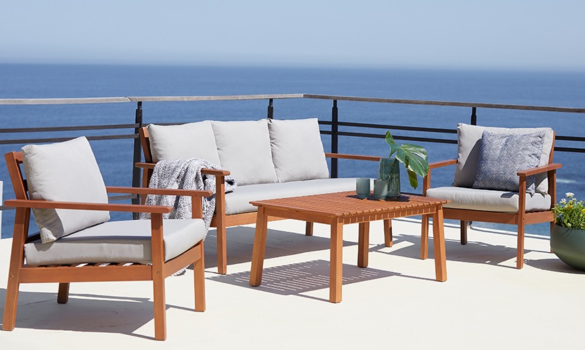Lesen lounge vrtni set z leseno mizo, lounge zofo in dvema lounge vrtnima stoloma na terasi ob morju