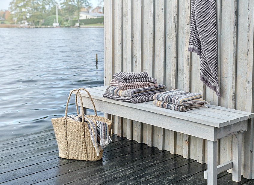 Luksuzne brisače za na plažo v pleteni košari ob jezeru
