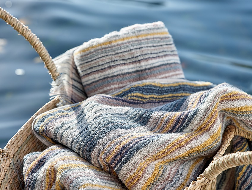 Pletena košara z črtastami brisačami ob jezeru