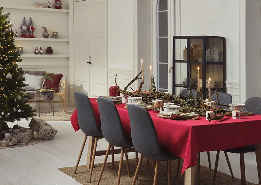 Jedilna miza okrašena za božič in božično drevo z darili