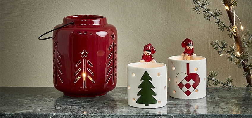 Božična lanterna v rdeči barvi in svečnik z božičnimi motivi