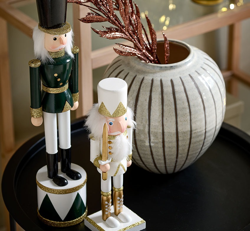 Božični figuri hrestač in vaza na črni mizi