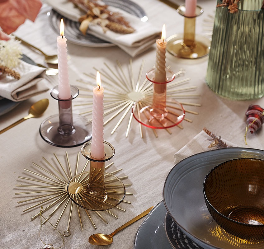 Dekoracija v zlati barvi, svečniki in sveče na silvestrsko pogrnjeni mizi