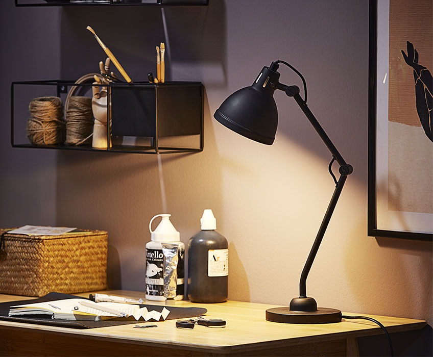 Črna namizna svetilka na pisalni mizi