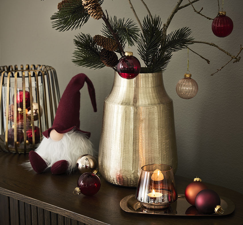 Zlat svečnik, božični škrati in zlata vaza z vejami in novoletnimi kroglicami
