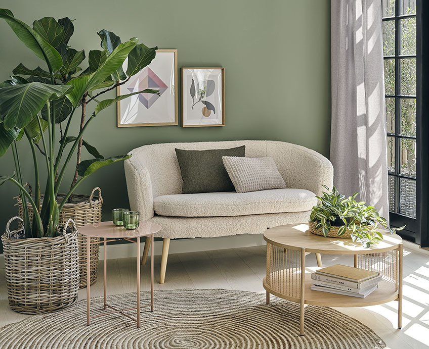 Dnevna soba z zofo, klubsko mizico v barvi svetlega hrastain zelenimi rastlinami
