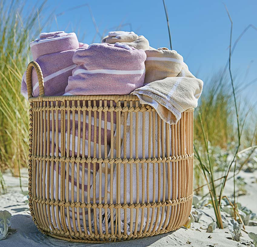 Kopalne brisače v košari z ročaji na plaži